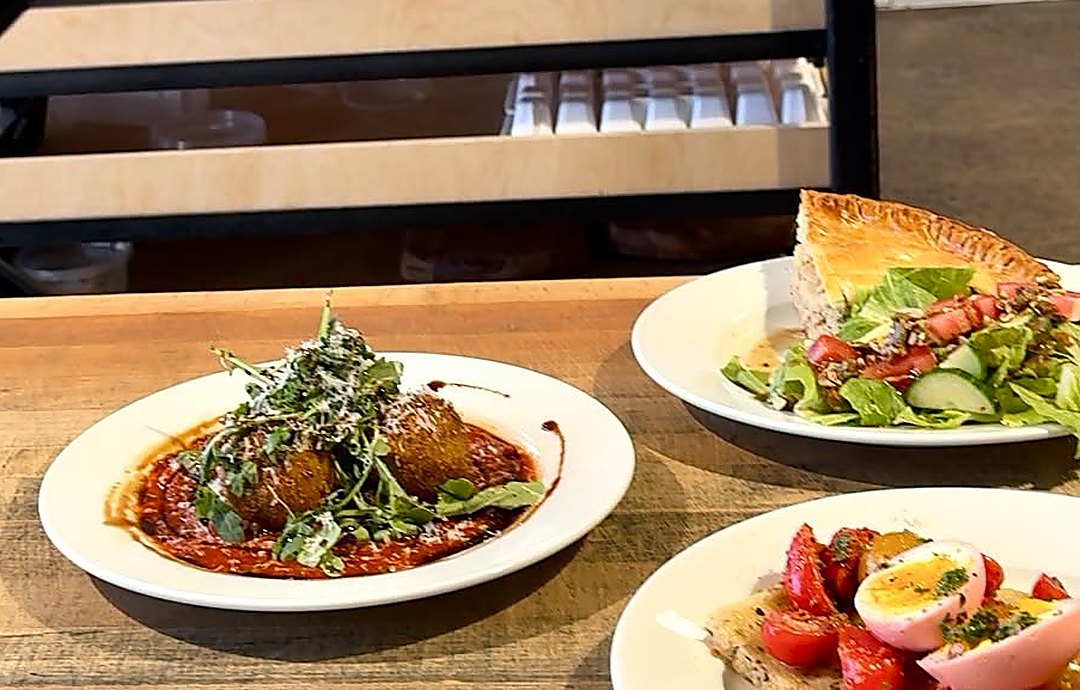 Assiettes du midi : quiche, salade et plat chaud sur le comptoir de bois