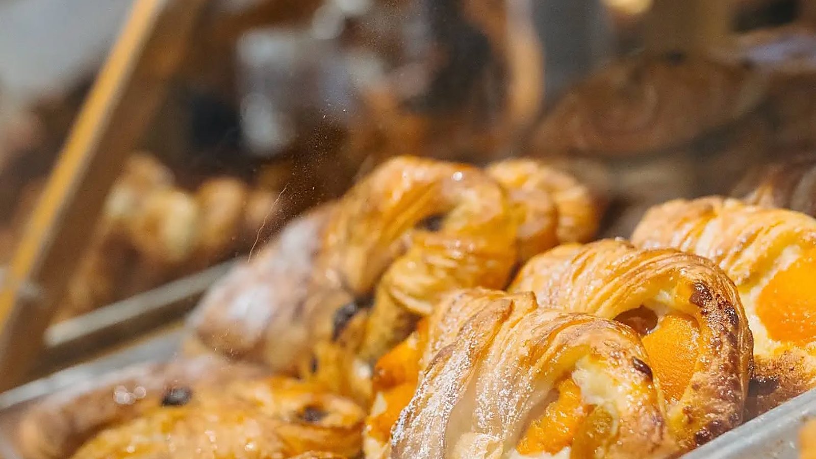 Viennoiseries dorées alignées dans la vitrine de la boulangerie